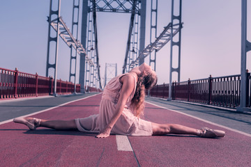 Great stretching. Beautiful attractive woman doing the splits while being on the bridge © Viacheslav Yakobchuk