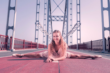 Great mood. Joyful female dancer smiling to you while doing splits © Viacheslav Yakobchuk