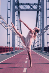 Ballet dancer. Nice young woman showing her dancing skills while being on the bridge © Viacheslav Yakobchuk
