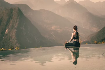 Poster Mooie aantrekkelijke Aziatische vrouw beoefent yoga Lotus pose op het zwembad boven de bergtop in de ochtend voor een prachtig uitzicht op de natuur, voel je zo comfortabel en ontspan in vakantie, warme toon © 220 Selfmade studio