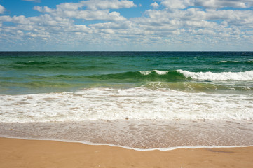 Big breaking Sea wave on a sandy beach on the shore of Sozopol in Bulgaria. Beautiful waves wash the beach with golden sand on a bright summer day.