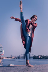 So beautiful. Nice attractive woman standing against the sky while holding her leg up © Viacheslav Yakobchuk