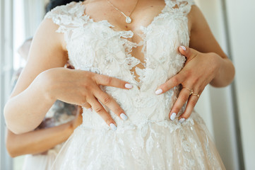 Gorgeous, blonde bride in white luxury dress is getting ready for wedding. Morning preparation