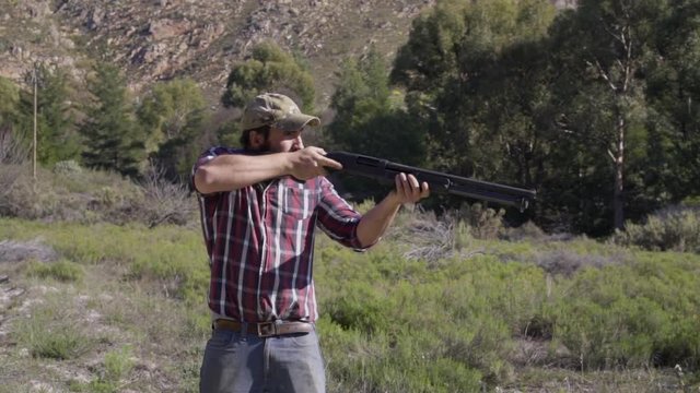 Man shooting multiple shotgun shots outdoors in nature