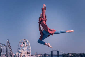 Real talent. Attractive young woman showing graceful movements while jumping in the air © Viacheslav Yakobchuk
