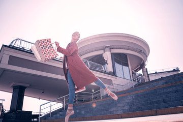 Wonderful mood. Attractive nice ballerina walking down the stairs while holding her bags © Viacheslav Yakobchuk