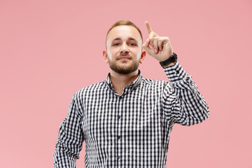 Fototapeta premium Happy businessman pointing up on pink studio background. Beautiful male half-length portrait. The human emotions, facial expression concept.