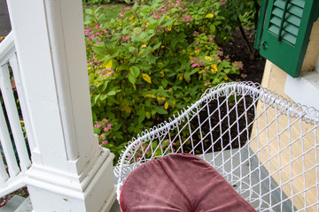 Home Sweet Home. Front porch with cozy outdoor seating and flowering shrub in the background. 
