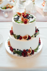 Beautiful cake covered with icing cream, summer berries on the top.