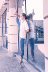 Ballet in my heart. Positive beautiful woman holding her leg up while dancing on the street © Viacheslav Yakobchuk