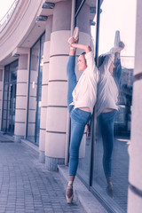 Masterful skills. Joyful professional dancer holding her leg up while showing her flexibility © Viacheslav Yakobchuk