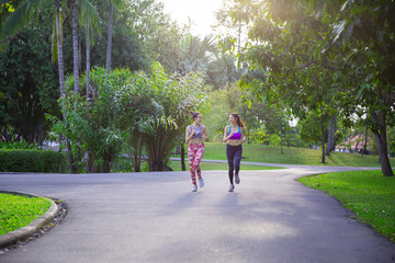 Sport background, womens is runing in park, They are talking smile and running together with Morning light effect filter. healthy concept.