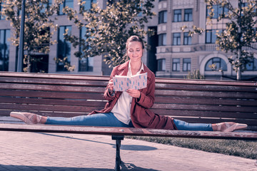 Pleasurable time. Smart young ballerina doing the splits on the bench while reading a book in the park © Viacheslav Yakobchuk