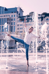 Sumer freshness. Nice graceful woman feeling the water while performing in the fountain © Viacheslav Yakobchuk