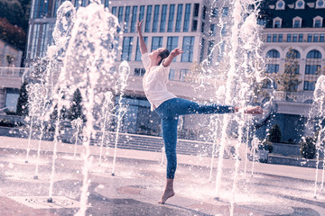 Feel everything. Beautiful professional ballerina dancing with bare feet while standing in the...