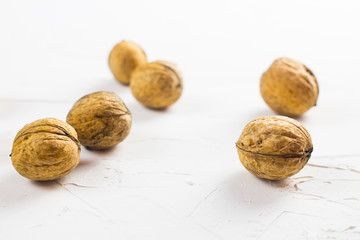 Walnuts on white textured surface. Close up.