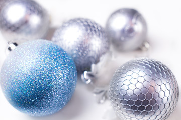 Silver and blue christmas toys on white background.