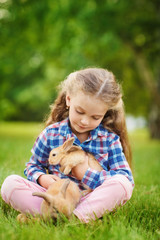 Girl with a cute little rabbit, outdoor, summer day