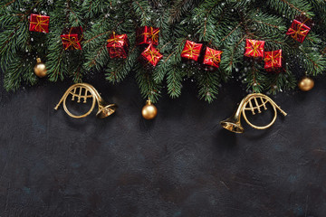 Christmas background with fir tree branches, Christmas decoration – stars, balls, trumpets, garland. Top view, close up