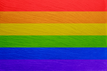 LGBT flag colors over slate textured background. Gay pride