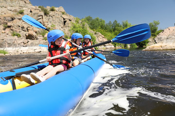 Naklejka premium Little children kayaking on river. Summer camp