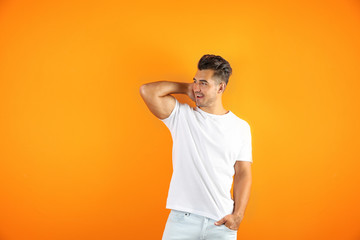 Fototapeta na wymiar Young man in t-shirt on color background. Mockup for design