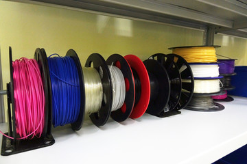 Color PLA and ABS plastic filament coils for 3D printer.