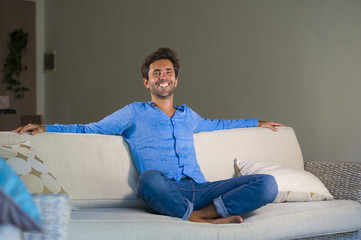 young attractive and happy 30s man smiling relaxed and comfortable sitting at living room sofa...