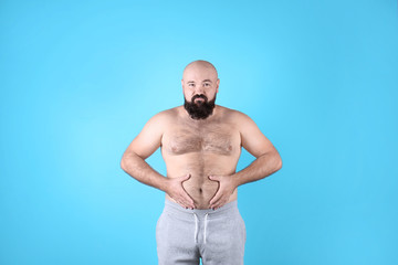 Fat man on color background. Weight loss