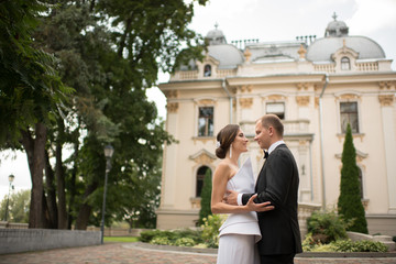 Married couple embracing near luxury building
