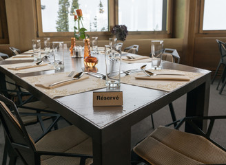 restaurant table with elegant place settings and a reserved sign written in French