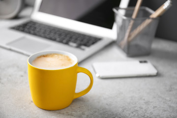 Yellow cup with coffee on office table. Space for text - Powered by Adobe