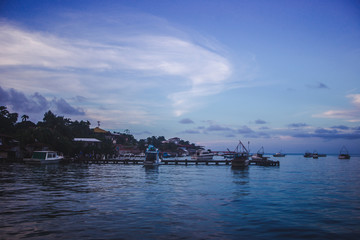 Naklejka premium Sunset over boats lined up at the docks of Lívingston, a Garifuna Caribbean town in east Guatemala