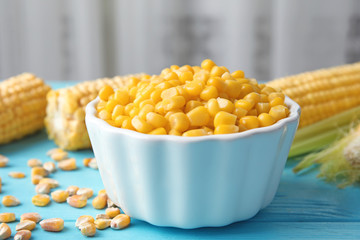 Bowl with corn kernels on blue wooden table