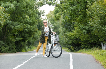 Beautiful woman in casual outfit with bicycle outdoors