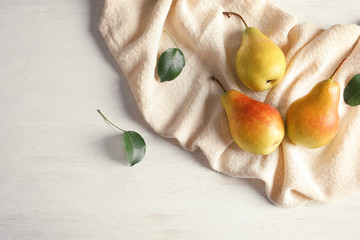 Flat lay composition with ripe pears on white wooden background. Space for text