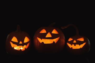 Halloween pumpkin heads. Glowing jack lanterns in dark