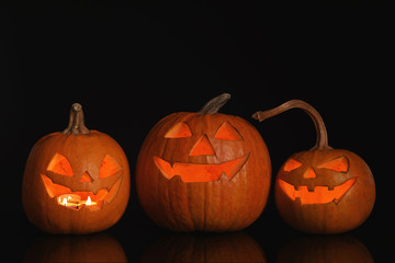 Halloween pumpkin heads. Glowing jack lanterns on dark background