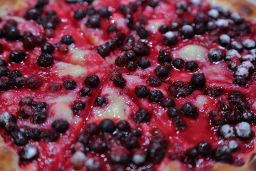 Delicious dessert pizza with wild berries and sugar powder

