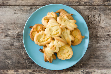Homemade Halloween cookies in plate on wooden table background. Top view.