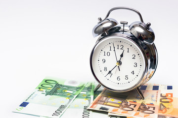 alarm clock, and European paper money, on a white background. Business concept, time is money.