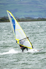 Man windsurfing close to the town of Caernarfon in Wales - United Kingdom
