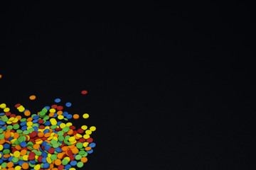 abstract black background with colorful candy confetti