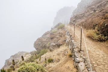 Hiking trail in between clouds. Pico do Arieiro, at 1,818 m high, is Madeira Island's third highest...