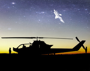 Spaceship flying into outer space. Space travel. Silhouette of helicopter and people at sunset. Air tourism. Some elements of this image are furnished by NASA