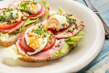 Sandwich with tomatoes, eggs and lettuce.