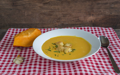 Delicious pumpkin soup with croutons on checkered napkin