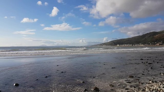 Footage of Fairbourne beach in Wales with waves lapping the shore.