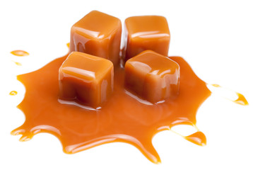 Sweet Caramel candies with caramel topping  sauce isolated on a white background close up.