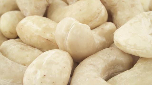 Macro shooting of a cashew nuts heap. Rotating on the turntable. Isolated on the white background. Close up.